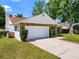 Charming home featuring stone accents, white siding, a two-car garage and neat landscaping at 2720 Wiltshire Ave, Palm Harbor, FL 34685