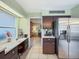 Kitchen area with stainless steel refrigerator and desk workspace at 2720 Wiltshire Ave, Palm Harbor, FL 34685