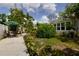 View of the backyard showcasing mature landscaping, a garden area, and a patio set at 2805 W Patterson St, Tampa, FL 33614