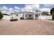 Charming single-story home with a large brick driveway, manicured landscaping, and quaint front porch seating at 2805 W Patterson St, Tampa, FL 33614