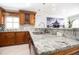 Close up of the kitchen with granite countertops, stainless steel sink and faucet, and wooden cabinets at 2805 W Patterson St, Tampa, FL 33614
