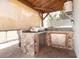 View of the outdoor kitchen featuring stone backsplash, a built-in sink, and stainless steel appliances at 2805 W Patterson St, Tampa, FL 33614