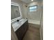 Beautiful bathroom with a modern vanity, gray cabinets, marble-like tiling in the shower, and a window at 29813 69Th N St, Clearwater, FL 33761