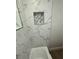 Modern bathroom featuring marble-like tiling and a shower niche at 29813 69Th N St, Clearwater, FL 33761