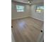 A bright bedroom with new floors, a modern ceiling fan, and two windows, flooding the room with natural light at 29813 69Th N St, Clearwater, FL 33761