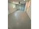 View of the spacious garage with a window, overhead door, and a clean, painted floor at 29813 69Th N St, Clearwater, FL 33761