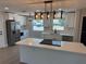 Modern kitchen features white cabinets, stainless steel appliances, and a center island with countertop seating at 29813 69Th N St, Clearwater, FL 33761