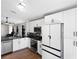 The kitchen boasts white cabinets, stainless steel appliances, and black countertops at 302 Summer Sails Dr, Valrico, FL 33594
