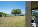 Backyard view featuring the lawn, lake and seating with an accent column at 30526 Annadale Dr, Wesley Chapel, FL 33545