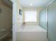 Bathroom showcasing tub, window and enclosed glass shower at 30526 Annadale Dr, Wesley Chapel, FL 33545