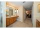 Long hallway with a bathroom vanity featuring wood cabinetry and a mirror at 30526 Annadale Dr, Wesley Chapel, FL 33545