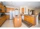 Well-equipped kitchen features wood cabinetry, granite counters, a central island, and modern appliances for cooking convenience at 30526 Annadale Dr, Wesley Chapel, FL 33545