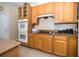 Kitchen featuring wood cabinets, granite countertops, a flat cooktop, and double ovens for convenient cooking at 30526 Annadale Dr, Wesley Chapel, FL 33545