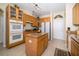 Kitchen boasts wood cabinets, granite countertops, a center island, and appliances, ideal for culinary enthusiasts at 30526 Annadale Dr, Wesley Chapel, FL 33545