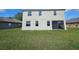Exterior view of the home from backyard, showing a screened-in patio and a spacious grassy area at 3109 Chessington Dr, Land O Lakes, FL 34638
