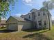 Two-story home with an attached two-car garage, manicured lawn, and palm tree, showcasing curb appeal at 3109 Chessington Dr, Land O Lakes, FL 34638