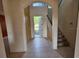 Foyer with tile flooring, staircase, and archway leading to the front door at 3109 Chessington Dr, Land O Lakes, FL 34638