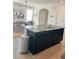 Kitchen island with seating, stainless steel appliances, and dark wood cabinets at 32699 Dashel Palm Ln, Wesley Chapel, FL 33543
