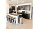 Kitchen featuring an island with seating, stainless steel appliances, and dark wood cabinets at 32699 Dashel Palm Ln, Wesley Chapel, FL 33543
