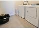 Laundry room features a full size washer and dryer on tiled flooring at 32699 Dashel Palm Ln, Wesley Chapel, FL 33543