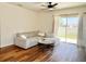 Living room with a comfortable couch, a ceiling fan, and sliding glass doors leading to the backyard at 32699 Dashel Palm Ln, Wesley Chapel, FL 33543