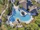 Aerial view of a community pool surrounded by palm trees and lush landscaping at 32699 Dashel Palm Ln, Wesley Chapel, FL 33543