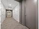 Hallway with neutral carpet and gray accent door showcasing access to storage units at 332 Cocoanut Ave # 505, Sarasota, FL 34236