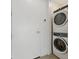 Bright laundry room with front-loading washer and dryer on top of one another with white door at 332 Cocoanut Ave # 505, Sarasota, FL 34236