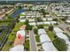 An aerial view showcasing a home with a reddish-brown roof in a lakeside community at 3928 90Th N Ter, Pinellas Park, FL 33782