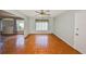 Inviting living room with wood floors, fan, and ample natural light from a large window at 3928 90Th N Ter, Pinellas Park, FL 33782