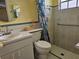 A functional bathroom with a sink, toilet, shower with curtain, and handicap bar at 4206 Tamargo Dr # 4206, New Port Richey, FL 34652