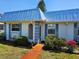Charming home featuring a blue metal roof, blue shutters, and manicured landscaping at 4206 Tamargo Dr # 4206, New Port Richey, FL 34652