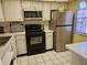 Charming kitchen with stainless steel refrigerator, black stove and white cabinets at 4206 Tamargo Dr # 4206, New Port Richey, FL 34652