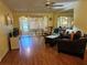A comfortable living room features hardwood floors, a ceiling fan, and access to the enclosed patio at 4206 Tamargo Dr # 4206, New Port Richey, FL 34652
