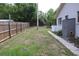 View of a level backyard with grass and a tall mature tree and a shed at 4363 Elwood Rd, Spring Hill, FL 34609