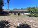 Fenced backyard with a screened-in porch attached to the house and a few trees at 4363 Elwood Rd, Spring Hill, FL 34609