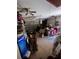 View of a cluttered garage with two ceiling fans and a garage door at 4363 Elwood Rd, Spring Hill, FL 34609