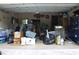 View of a cluttered garage with boxes and several black garbage bags at 4363 Elwood Rd, Spring Hill, FL 34609