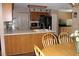 Inviting kitchen featuring wood cabinets, white countertops, and a charming breakfast bar at 4363 Elwood Rd, Spring Hill, FL 34609