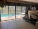 Living room with tile flooring, sliding glass door and views of the backyard pool at 4363 Elwood Rd, Spring Hill, FL 34609