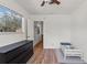 Bright bedroom features wood-look flooring, large window for natural light, and a ceiling fan at 4400 2Nd S Ave, St Petersburg, FL 33711