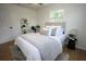 Relaxing bedroom featuring a neatly made bed, decorative shelf, and ample natural light at 4735 W Wisconsin Ave, Tampa, FL 33616