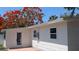 Rear exterior of home featuring clean lines, white siding, windows, and a back door at 4735 W Wisconsin Ave, Tampa, FL 33616