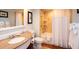 Well-lit bathroom with granite vanity and shower and tub with curtain at 5500 Gulf Blvd # 2249, St Pete Beach, FL 33706