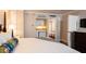Bright bedroom featuring queen bed, dark furniture, and a mini-kitchen and bathroom view at 5500 Gulf Blvd # 2249, St Pete Beach, FL 33706