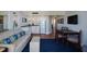Comfortable living area with modern furnishings, flat screen television, and adjacent kitchen with white cabinetry at 5500 Gulf Blvd # 2249, St Pete Beach, FL 33706