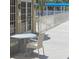 An outside patio with glass table and four chairs with an open walkway in the background at 5500 Gulf Blvd # 2249, St Pete Beach, FL 33706