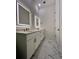 Modern bathroom featuring double vanity, illuminated mirrors, and elegant marble-patterned tile floor at 600 3Rd S Ave # 503, St Petersburg, FL 33701