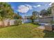 Open backyard featuring green grass, a screened lanai, and a white privacy fence at 6219 57Th N Ave, St Petersburg, FL 33709
