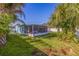 Spacious backyard with lush grass, a screened lanai, and a white fence at 6219 57Th N Ave, St Petersburg, FL 33709